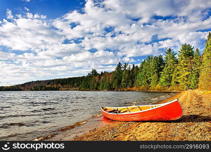 Red canoe on lake shore