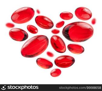 Red capsules in the shape of a heart on a white background.. Red capsules in the shape of a heart on a white background