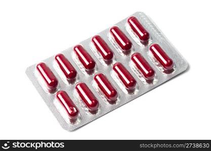 Red capsules packed in blister isolated on white