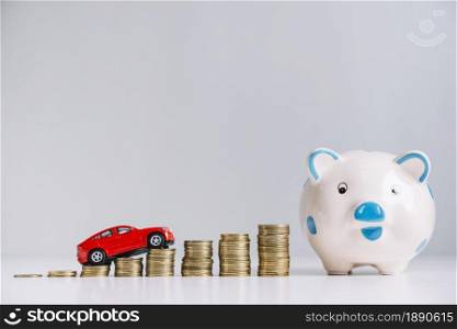 red car driving increasing stacked coins near piggybank . Resolution and high quality beautiful photo. red car driving increasing stacked coins near piggybank . High quality and resolution beautiful photo concept
