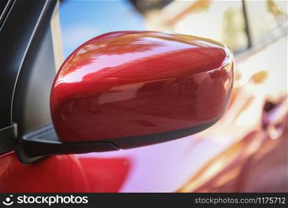 Red car with side rear view mirror on a modern car side mirror front