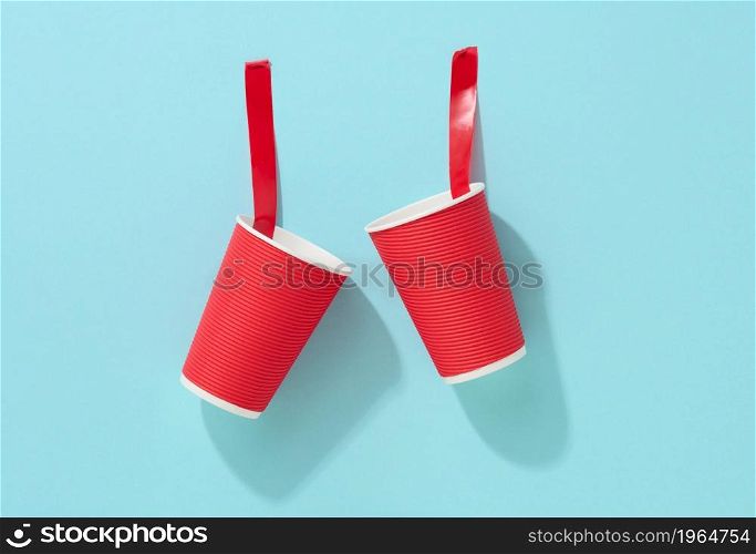 red cardboard cup glued with red sticky tape to the blue background