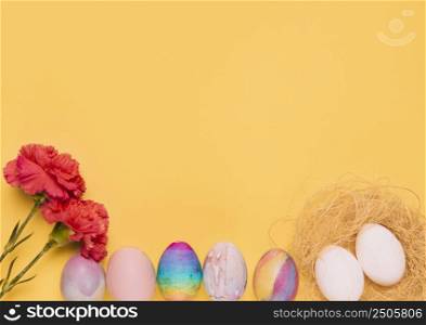red carnation flowers with colorful easter eggs yellow background