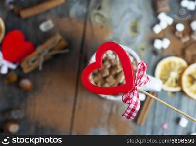 red carved wooden heart on background table with drink, top view