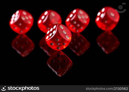 Red casino dice isolated over black reflective background.. Red casino dice isolated over black reflective background