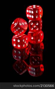 Red casino dice isolated over black reflective background.. Red casino dice isolated over black reflective background