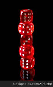 Red casino dice isolated over black reflective background.. Red casino dice isolated over black reflective background