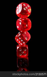 Red casino dice isolated over black reflective background.. Red casino dice isolated over black reflective background