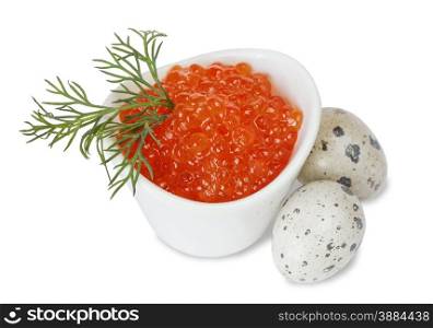 Red caviar in a porcelain bowl with a sprig of fennel and two quail eggs closeup