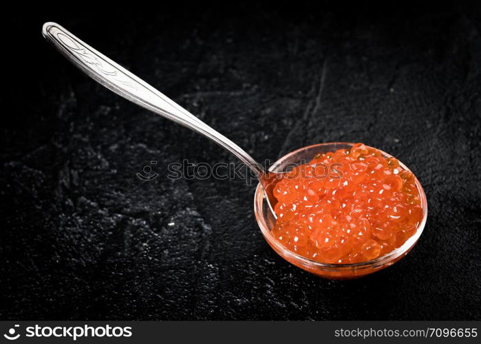 Red Caviar in bowl over black background