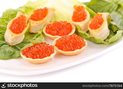 Red caviar in pastries and lettuce on plate.