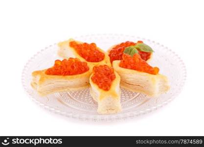 Red caviar in pastries on glass transparent plate.
