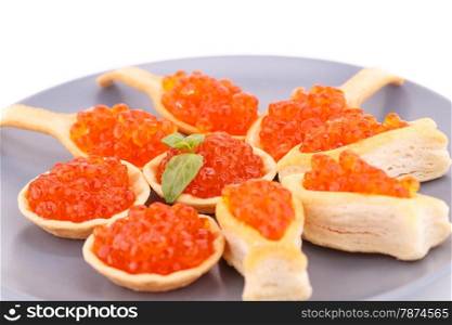Red caviar in pastries on gray plate.