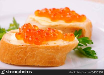 Red caviar sandwiches on plate. Shallow DOF