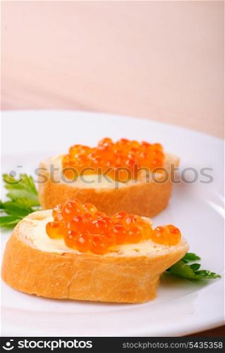 Red caviar sandwiches on plate. Shallow DOF