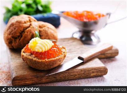 red caviar with bread and butter on a table