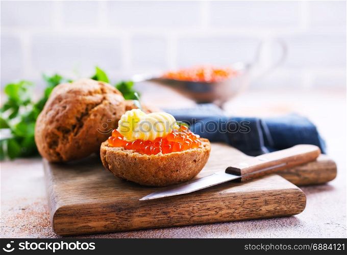 red caviar with bread and butter on a table