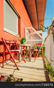 Red chairs on a cozy summer balcony, holiday feeling
