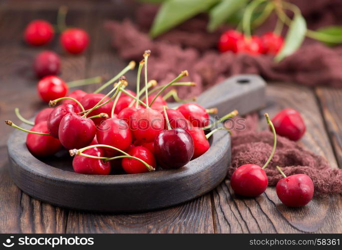 red cherry in bowl and on a table