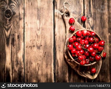 Red cherry in the Cup on the Board. On a wooden table. Red cherry in the Cup on the Board.