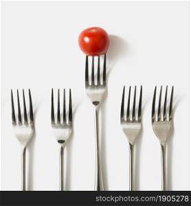 red cherry tomato fork against white background. Beautiful photo. red cherry tomato fork against white background