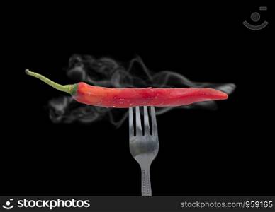 Red chili pepper is pierced a fork with smoke,food concept