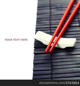 Red chopsticks on a bamboo serving mat