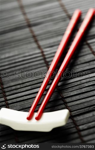 Red chopsticks on a bamboo serving mat