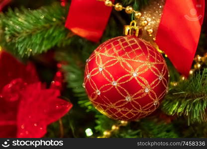 Red Christmas ball hanging on Christmas tree.