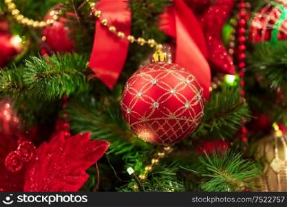 Red Christmas ball hanging on Christmas tree.