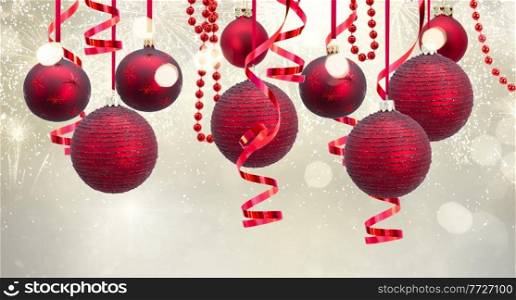 Red christmas balls hanging on festive glowing silver background. Red christmas balls