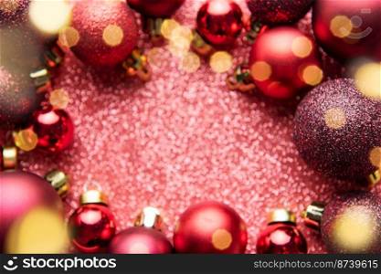 Red Christmas baubles decoration on red shiny background with copy space.