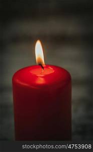 Red Christmas candle on a white wooden background