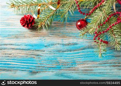 Red Christmas decorations and fir branch on a wooden background