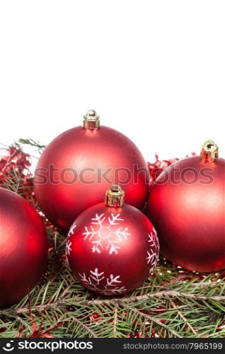 red Christmas decorations on green spruce tree branch isolated on white background