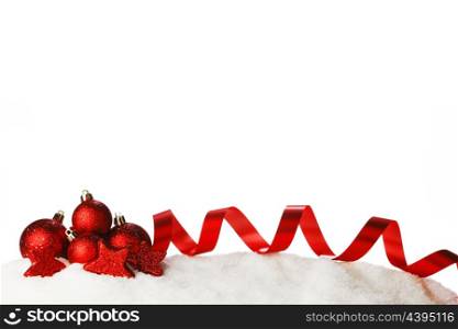 Red christmas decorative ribbons and balls on snow