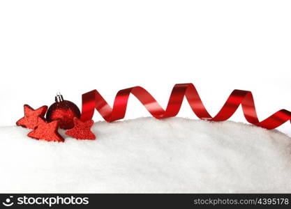 Red christmas decorative ribbons and balls on snow