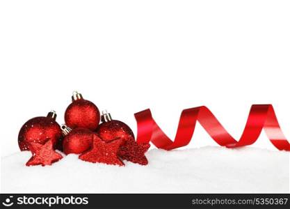 Red christmas decorative ribbons and balls on snow