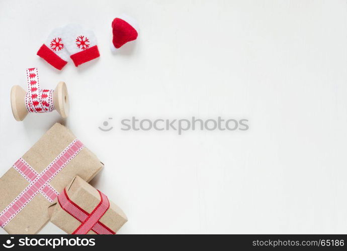 Red Christmas frame, consisting of gift boxes tied with ribbons, Santa's glove and mittens on a white background with space for text. Flat lay composition for greeting cards, websites, social media, magazines, bloggers, artists etc. Christmas wallpaper