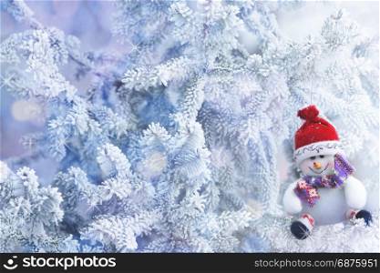Red Christmas Snowman Hanging on a Tree Branch in the Snow Winter Forest