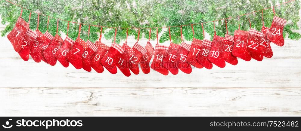 Red christmas socks and pine tree branches on bright wooden background. Winter holidays banner