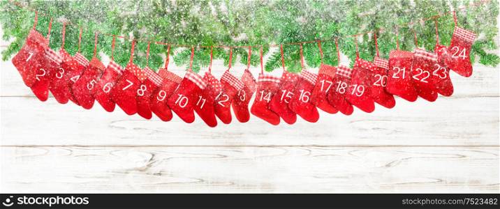 Red christmas socks and pine tree branches on bright wooden background. Winter holidays banner