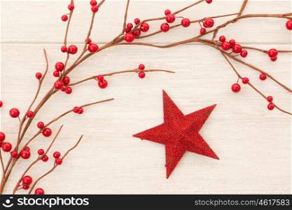 Red Christmas star on gray wooden background decorated with red berries