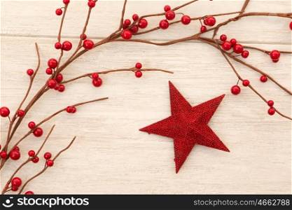 Red Christmas star on gray wooden background decorated with red berries