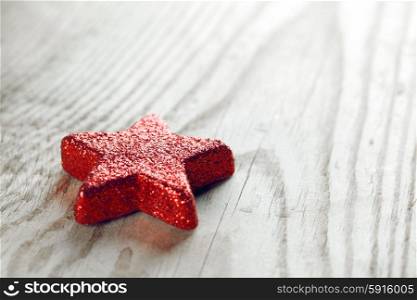 Red Christmas star . Red Christmas star on wooden background macro close-up