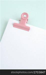 Red clip holding plain paper