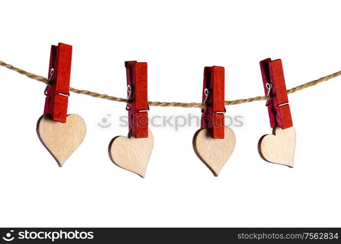 Red clothes pegs and wooden hearts on rope isolated on white background. Valentines day concept. Clothes pegs and hearts