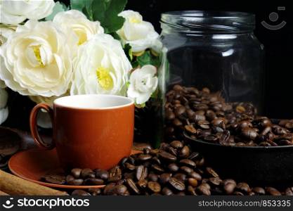 Red coffee cup and coffee beans on dark background