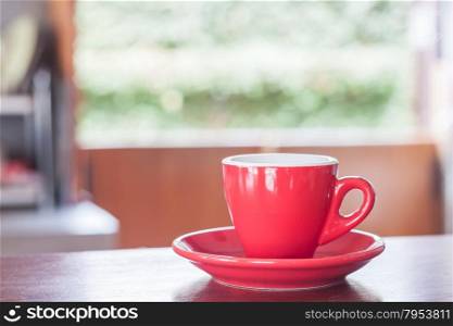 Red coffee cup on wooden table, stock photo