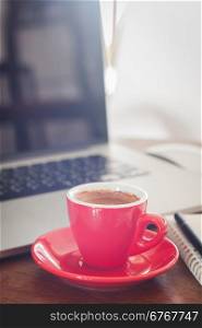 Red coffee cup with notepad and laptop, stock photo